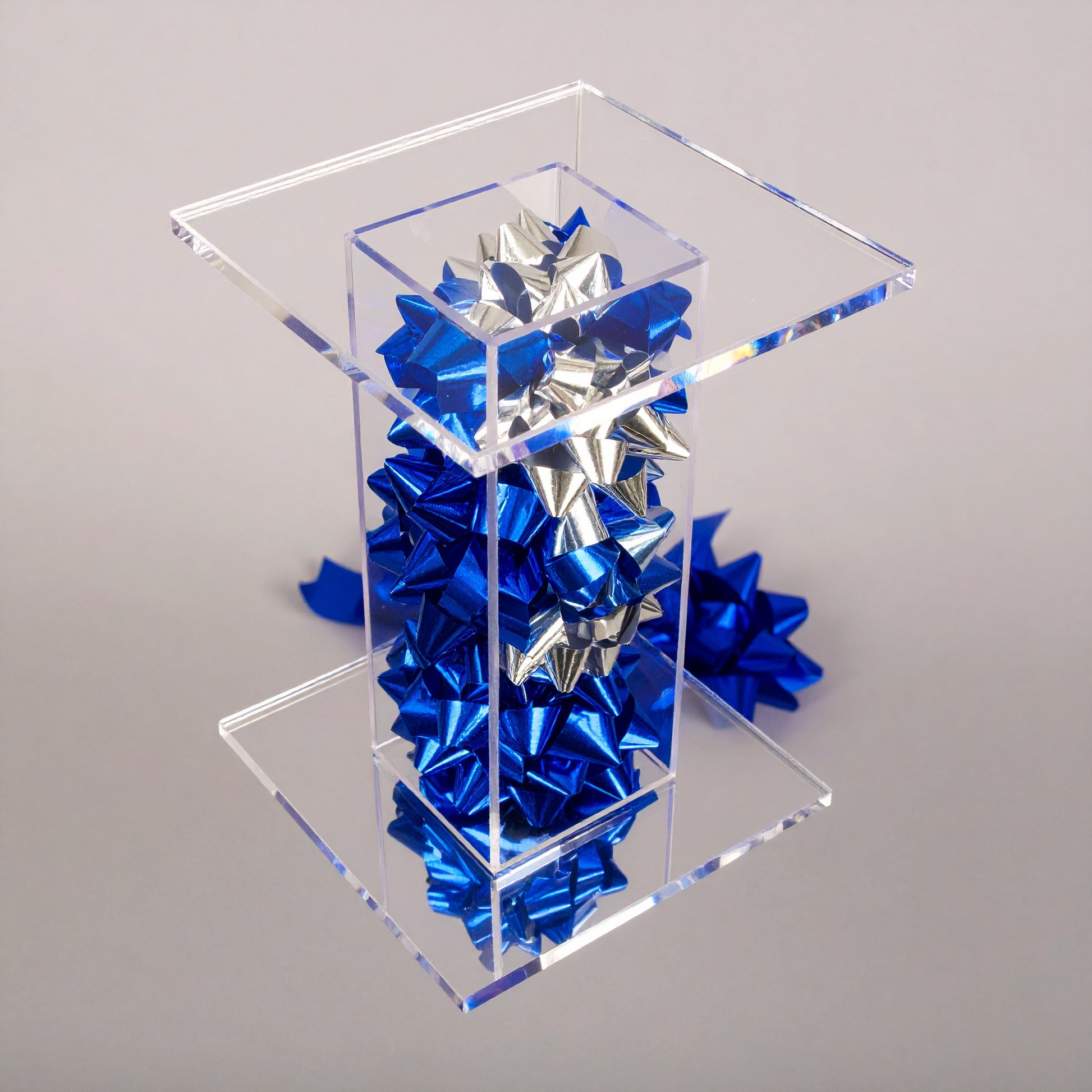 Bow Pedestal Stand — Clear Acrylic Event Riser – clear acrylic display stand for retail, showroom, or countertop use, size 4 x 4 x 4. Made in the USA by WebAcrylics.